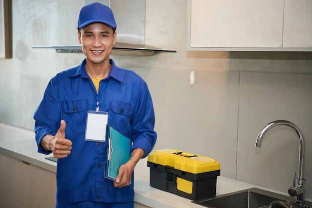 Plumber standing near the kitchen sink and showing thumb up