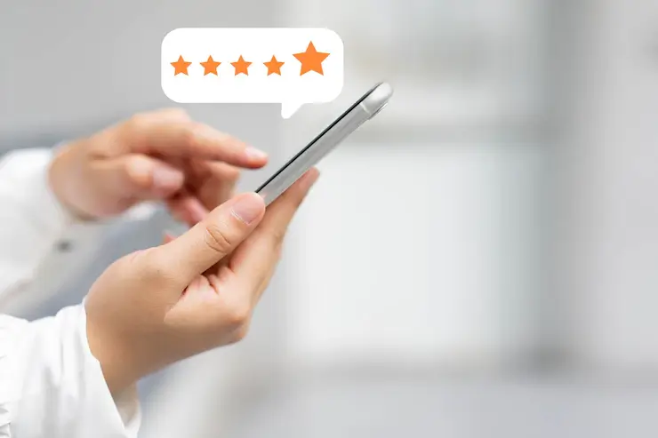Customer pressing on smartphone screen with five star rating feedback