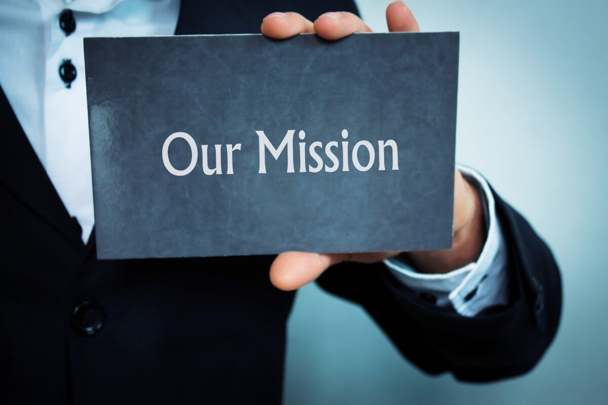 Businessman holding 'our mission' text